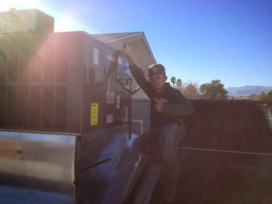 HVAC technician performing Air Duct Cleaning on a rooftop unit in Redland